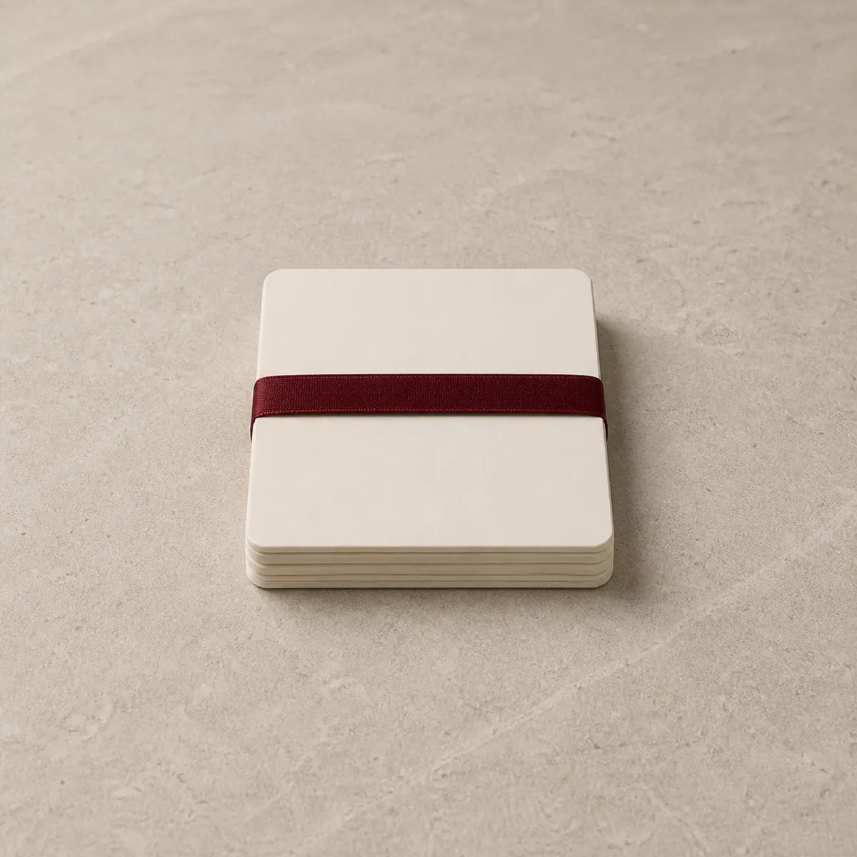 A stack of blank cream cards bound with a red ribbon