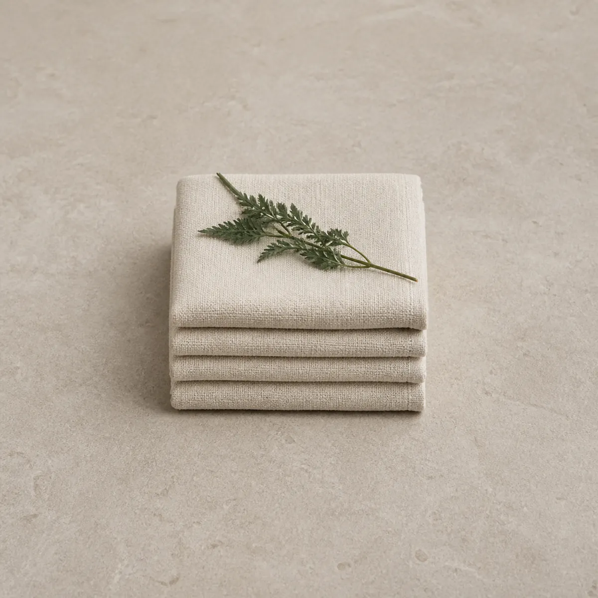 Folded linen towels with a sprig of mugwort